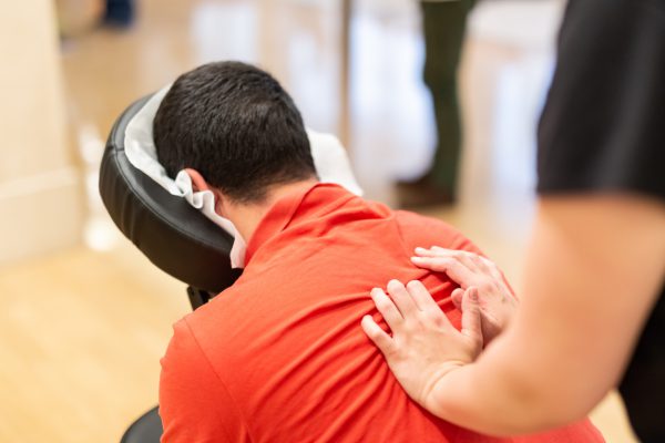 Man seated in a massage chair for back massage.